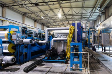 Çelik çatı oluşum makinesinin fotoğrafı. Metal kaplama çatı bobinleri için endüstriyel makine. Çelik kiremit yapımı süreci