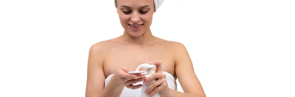 Een vrouw na een douche brengt een mousse voor gezichtsverzorging op een cosmetische wattenschijfje — Stockfoto