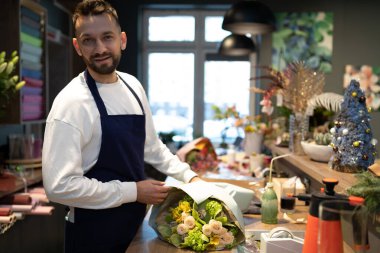 İş adamı çiçekçi bir buket taze çiçek yaratıyor.