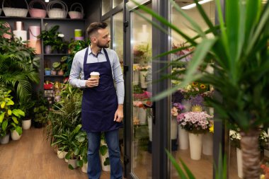 Çiçekçi dükkanının sahibi, buketli bir buzdolabının yanında.