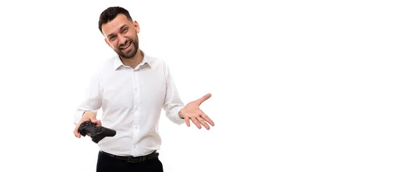 Joven en una camisa blanca con un joystick juego en sus manos indignado expandiendo sus manos gesto — Foto de Stock