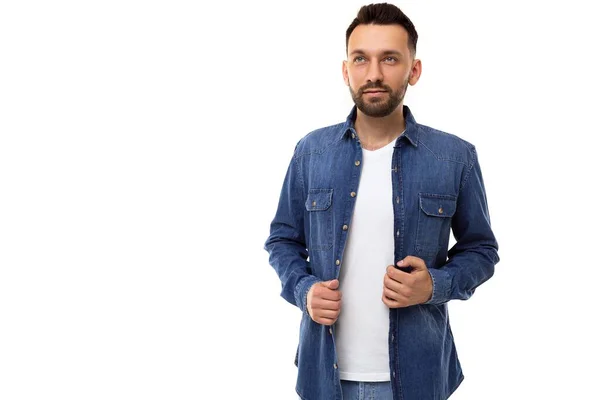 Confiado elegante hombre apuesto carismático en camiseta blanca y camisa azul denim se ve recto y hacia arriba —  Fotos de Stock