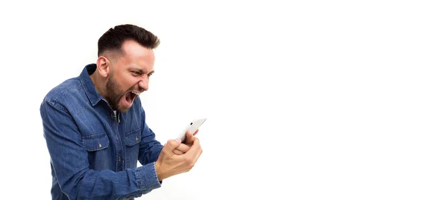 Muž držící telefon v ruce a dívající se na obrazovku emocionálně křičí radostí na bílém pozadí — Stock fotografie