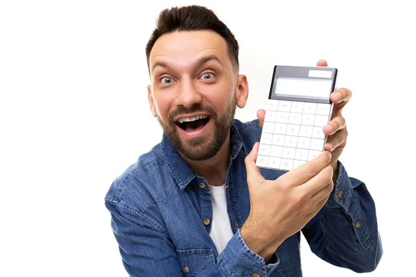 Charismatischer bärtiger Mann mittleren Alters mit einem Lächeln, der einen Taschenrechner auf weißem Hintergrund hält — Stockfoto