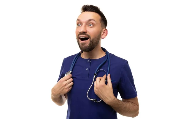 Stomverbaasd arts met een glimlach en een open mond op de achtergrond van een witte muur kijkt naar links — Stockfoto