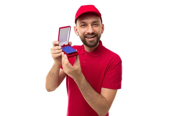 Bir kurye, kırmızı üniformalı orta yaşlı bir adamı elinde tutan bir çantada indirim kartı gösterir. — Stok fotoğraf