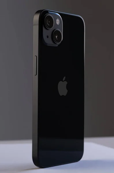 Nieuwe moderne mobiele telefoon iPhone 13 in zwarte kleur tegen een grijze muur — Stockfoto