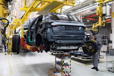 Minsk, Belarus - 15 Aralık 2021: araba cesetleri montaj hattında. Araba üretim fabrikası. Modern otomotiv endüstrisi. Yüksek teknoloji ürünü bir şirkette boyanmadan önce kontrol edilen bir araba.