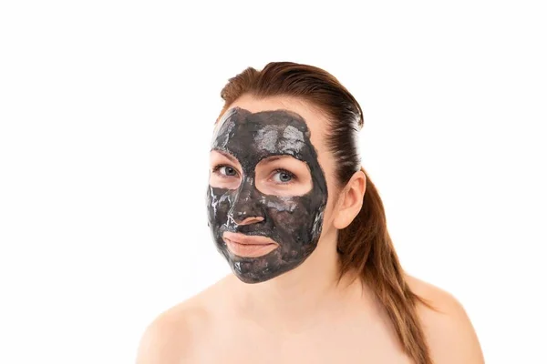 Duş aldıktan sonra yüzünün ve dudaklarının etrafında siyah bir kozmetik kilden maskeyle bir kadının yakın plan portresi. — Stok fotoğraf