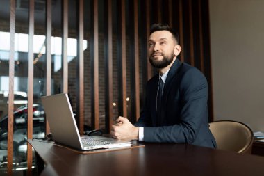 Ofisteki masada oturan takım elbiseli bir iş adamı.