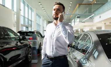 Genç, mutlu, gülümseyen, çekici, kıvırcık saçlı, samimi duyguları olan, kırmızı arka planda izole kırmızı kazak giyen bir kadının fotoğrafı.