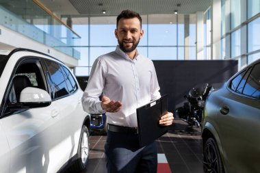 Bir araba galerisinde yeni arabalar için eşsiz bir teklif sunan satış müdürü.