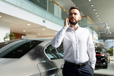 Alıngan, alıngan, üzgün, çekici, kıvırcık saçlı, samimi duyguları olan, kırmızı arka planda izole kırmızı kazak giyen kadının fotoğrafı.