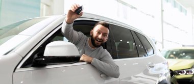 Katı takım elbiseli bir adam ofis duvarlarında dizüstü bilgisayarın arkasında çalışıyor.