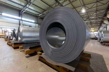 Metalik makine üretim hattının çatısındaki metal fayansların yakından çekilmiş fotoğrafı. Fabrikada soğuk çelik bobinler var.
