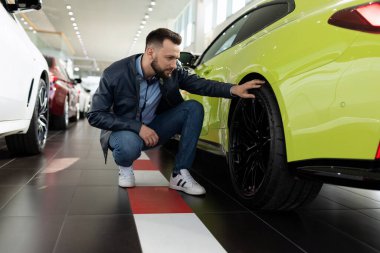 Bir kadın alıcı, galerinin araba galerisi çalışanından yeni bir araba için indirim talep eder.