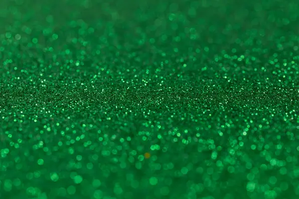 Green emerald background with depth of field in the middle, background with sparkles and glitters