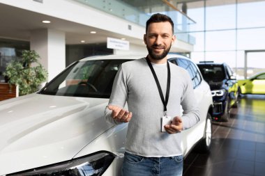 Bir araba galerisinde yönetici yeni bir araba alması için bir alıcıya teklif sunar.