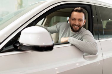 Orta yaşlı bir adam yeni bir araba aldı ve sigortaladı.