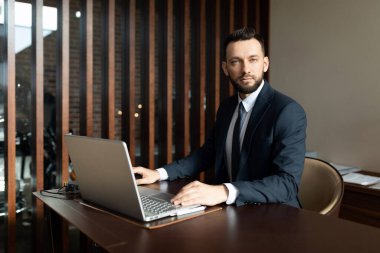 Bir dizüstü bilgisayarda şık bir ofiste, bir sigorta şirketinin saygın çalışanı.