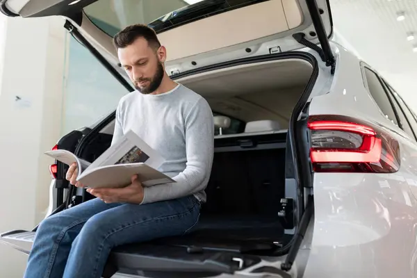 Orta yaşlı bir adam araba sigortası için sigorta şirketinin teklifini inceliyor.