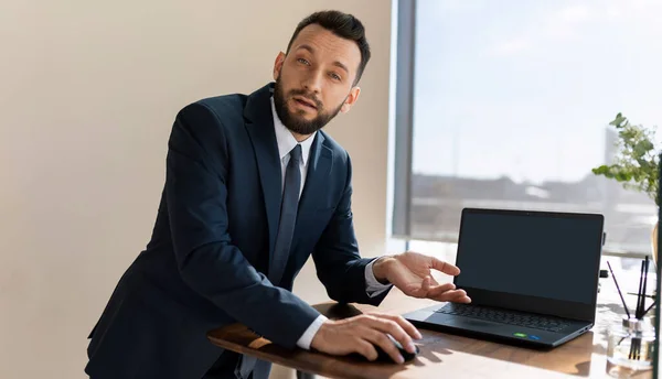 businessman next to a laptop conducts business correspondence