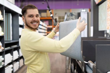 Yeni evleri için duvar kağıdı örneklerini inceleyen mutlu müşteriler..