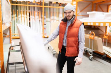 Bitiş malzemeleri mağazasından bir alıcı evinde onarım için kontrplak ve OSB panelleri seçer.