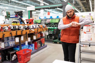 İnsan elektrikli aletleri saklar. Saatine bakar..