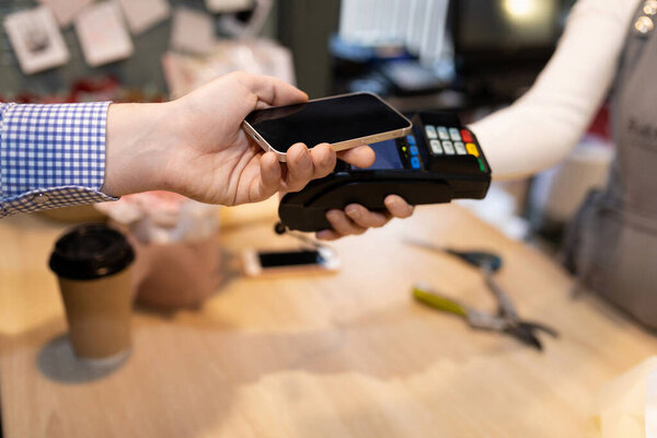 клиент оплачивает кредитной картой через беспроводной банковский терминал.