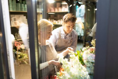 Buzdolabındaki çiçekçi işçileri taze çiçekleri kontrol ediyor..