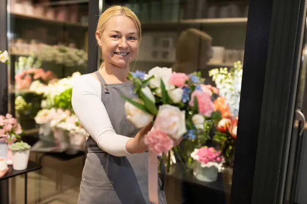 an employee of a flower shop looking at the camera with a smile.
