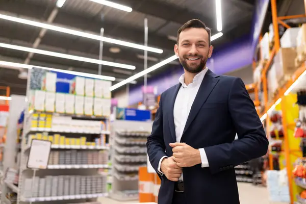 friendly manager of a hardware store in a business suit looking at the camera with a smile.