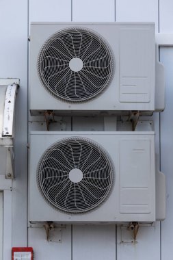 Binanın duvarında asılı duran havalandırma için soğutma ünitesi..