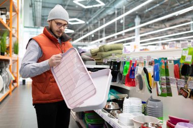 Sahibi, evcil hayvan dükkanında kedisi için plastik bir çöp kutusu seçiyor..