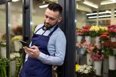 Mola sırasında erkek çiçekçi telefon için interneti besledi.