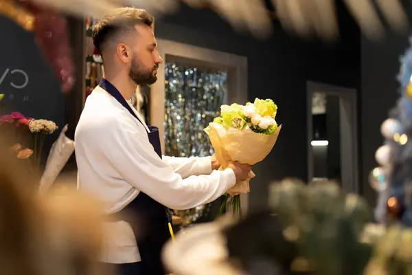 Bouquet designer in the workplace creates a composition of fresh flowers.