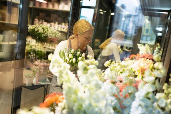 flower shop manager checks the quality of products in the refrigerator.