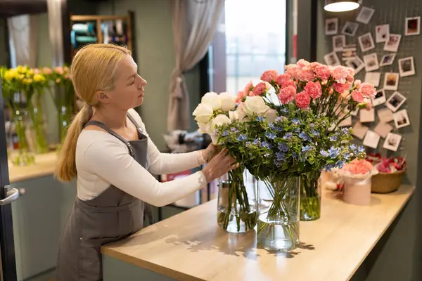 the manager of flower salons is preparing a bouquet of natural flowers for sending to the client by courier.