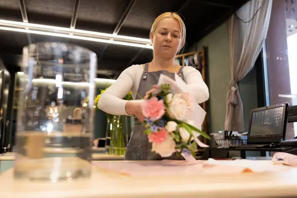 cutting flowers and creating a chic bouquet from them.