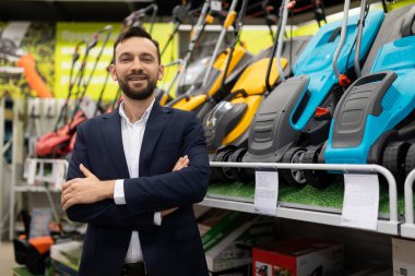 Elektrikli çim biçme makinesi satan bir mağaza müdürünün portresi..