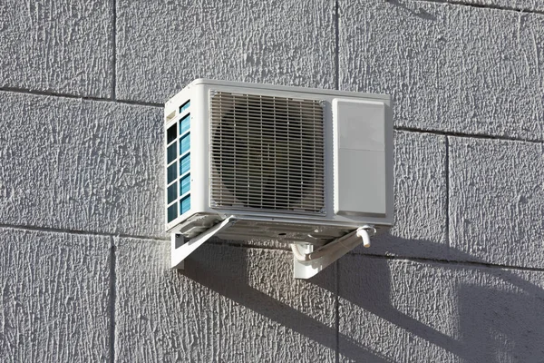 outdoor air conditioner unit with heat exchanger hanging outside the building.