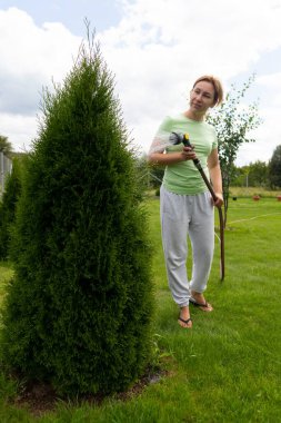 Bahçeye genç bir kadının hortumundan katil serpiyor..