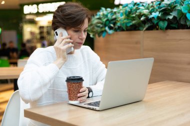 İş arayan genç bir kadın telefonda iş arıyor. Dizüstü bilgisayara bakıyor..