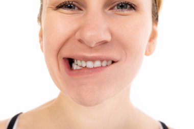 Genç bir kadın kameraya bakıp yüzünü buruşturuyor. Dişleriyle, yakından çekilmiş portresiyle..