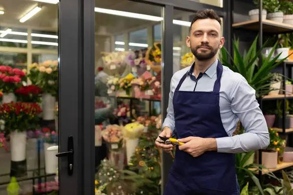 male florist on the background of the refrigerator with flowers and bouquets.