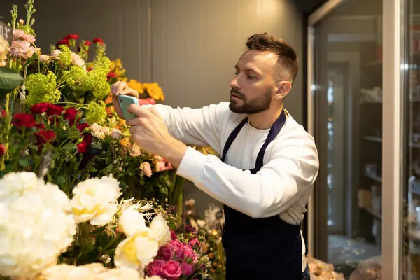florist chooses flowers for bouquets in the fridge.