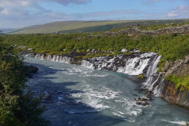 İzlanda 'nın Borgarfjordur Bölgesi: Hallmundarhraun' dan akan nehirlerden oluşan Hraunfossar şelaleleri, Langjokull buzulunun altındaki bir volkanın püskürmesiyle oluşan lav alanı..