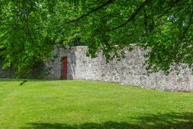 Gort, Co. Galway, İrlanda: Coole Park 'ın duvarlı bahçesinde kırmızı bir kapı.