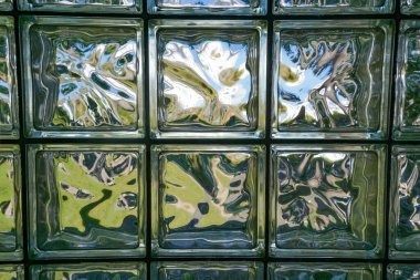 Cam bloklardan oluşan bir duvarda soyut desenler.